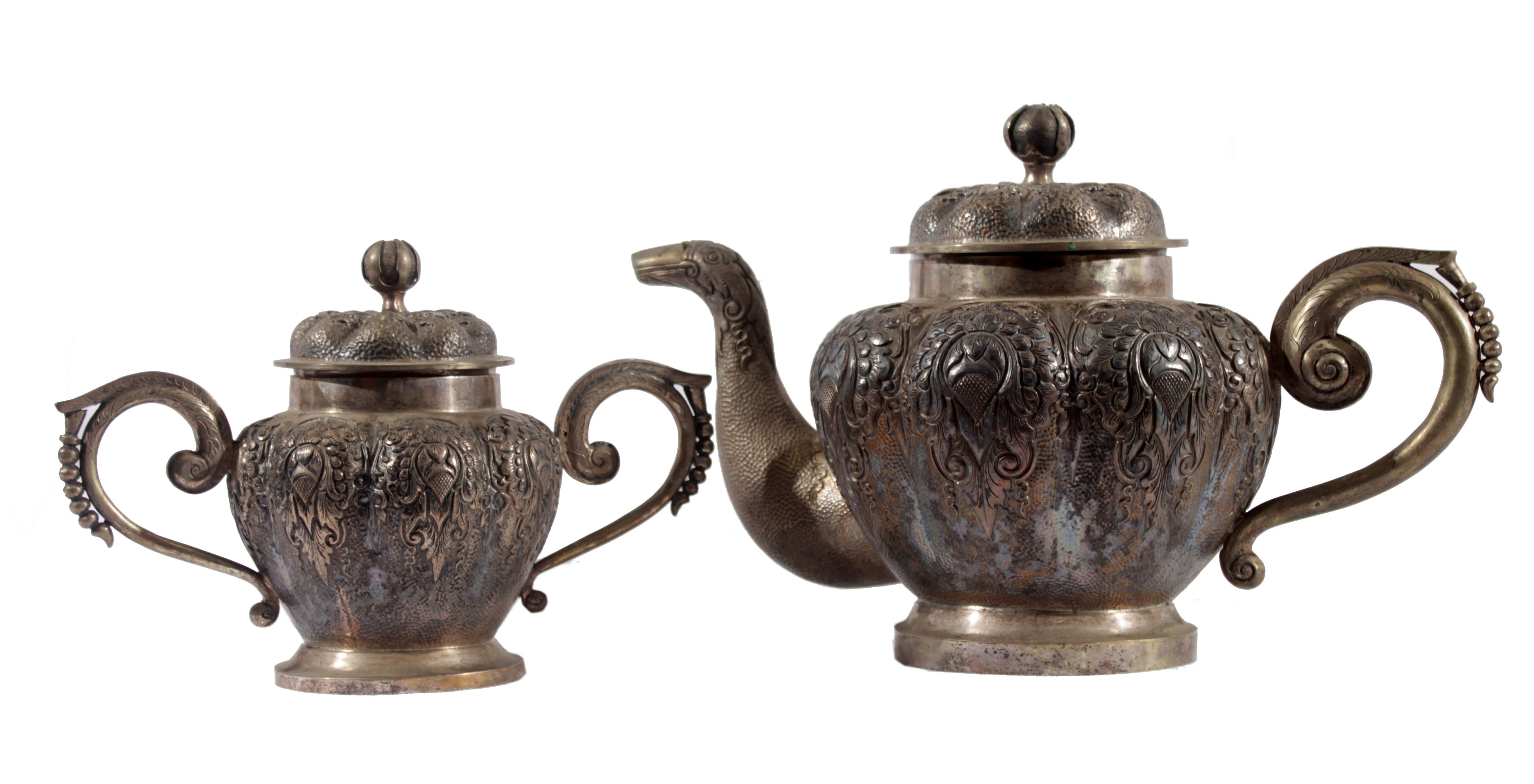 A silver tea pot and a sugar jar with lids.