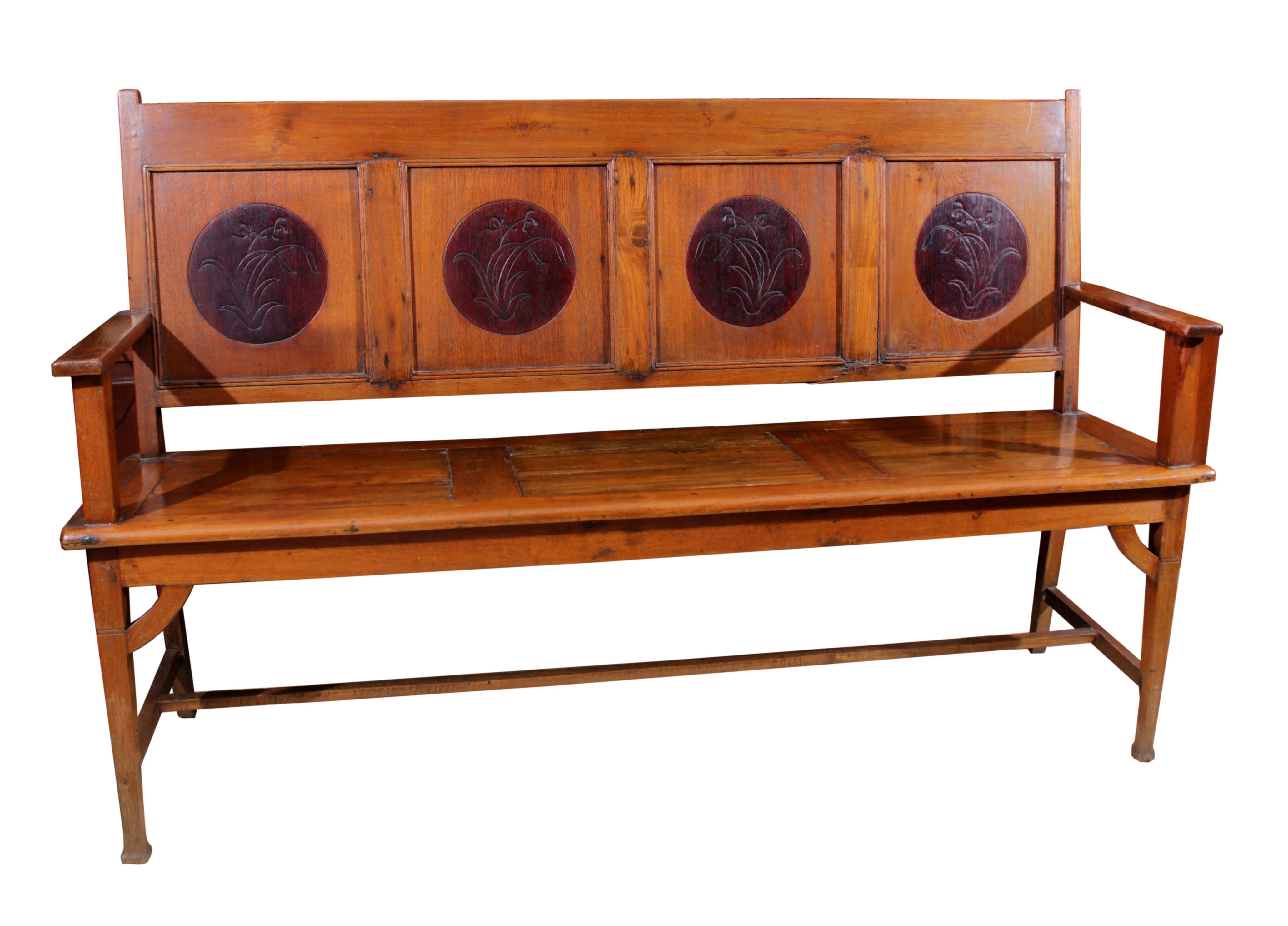 A wooden bench with circular ornaments on backrest.