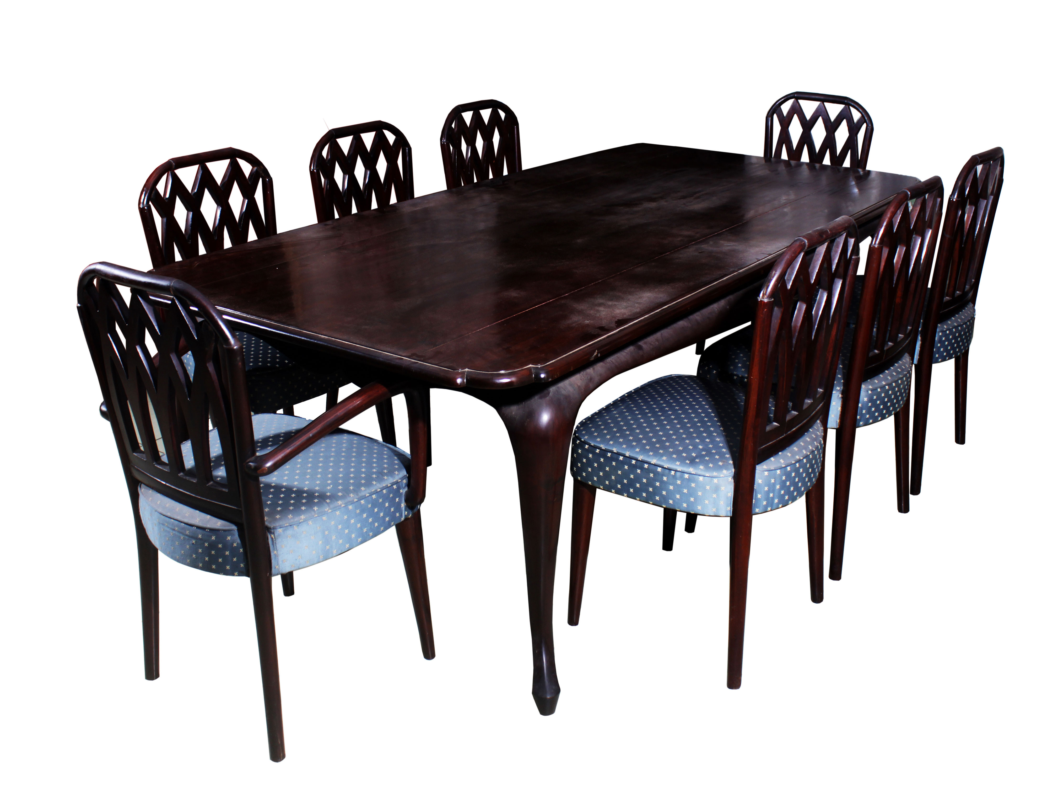 A set of dining room furniture, consisting of a wooden table with carving on the sides and eight blue upholstered chairs.