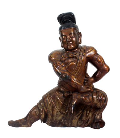 A Chinese wooden sculpture of a guardian figure. 