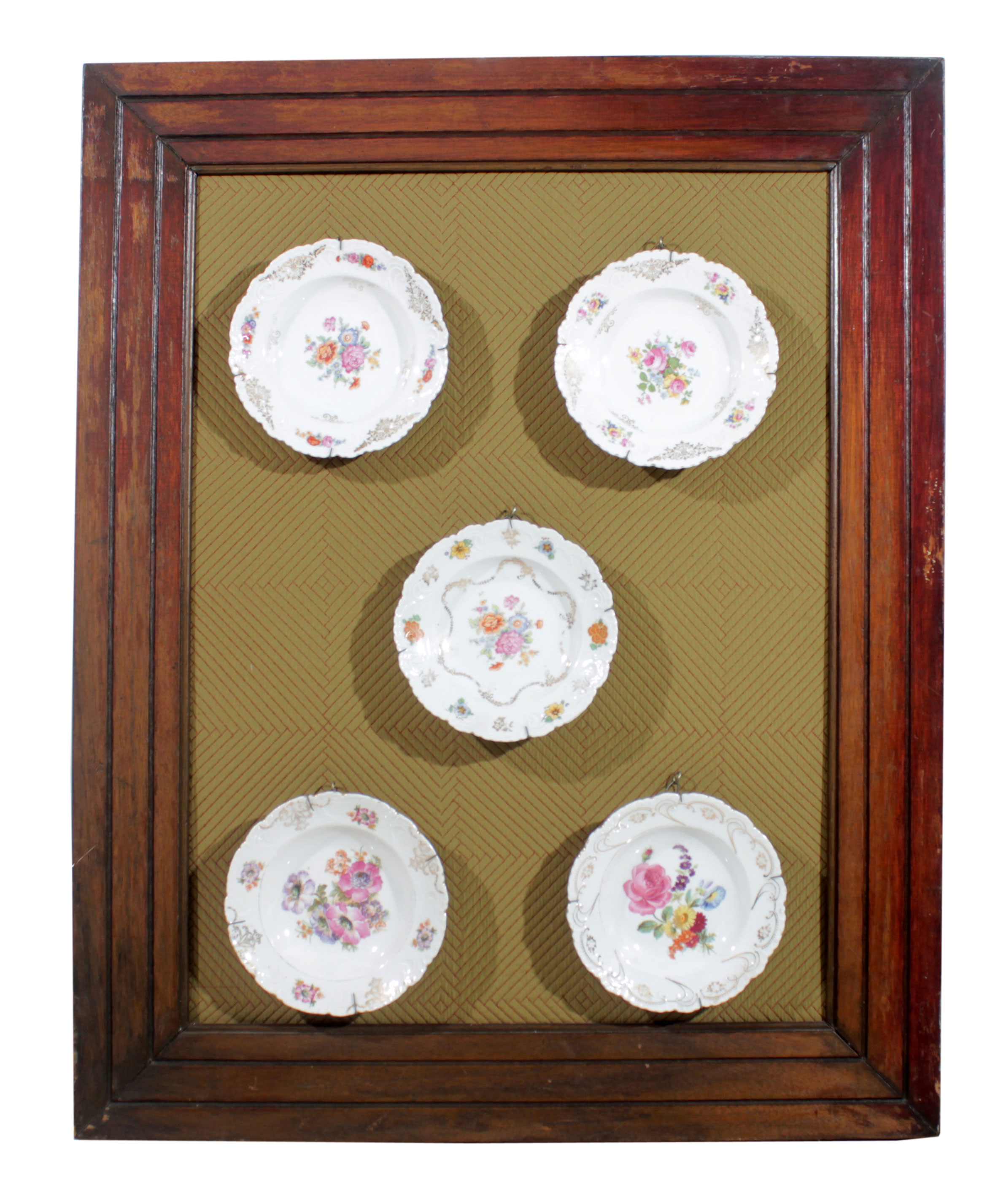 A framed set of five European ceramic dishes with floral decorations.