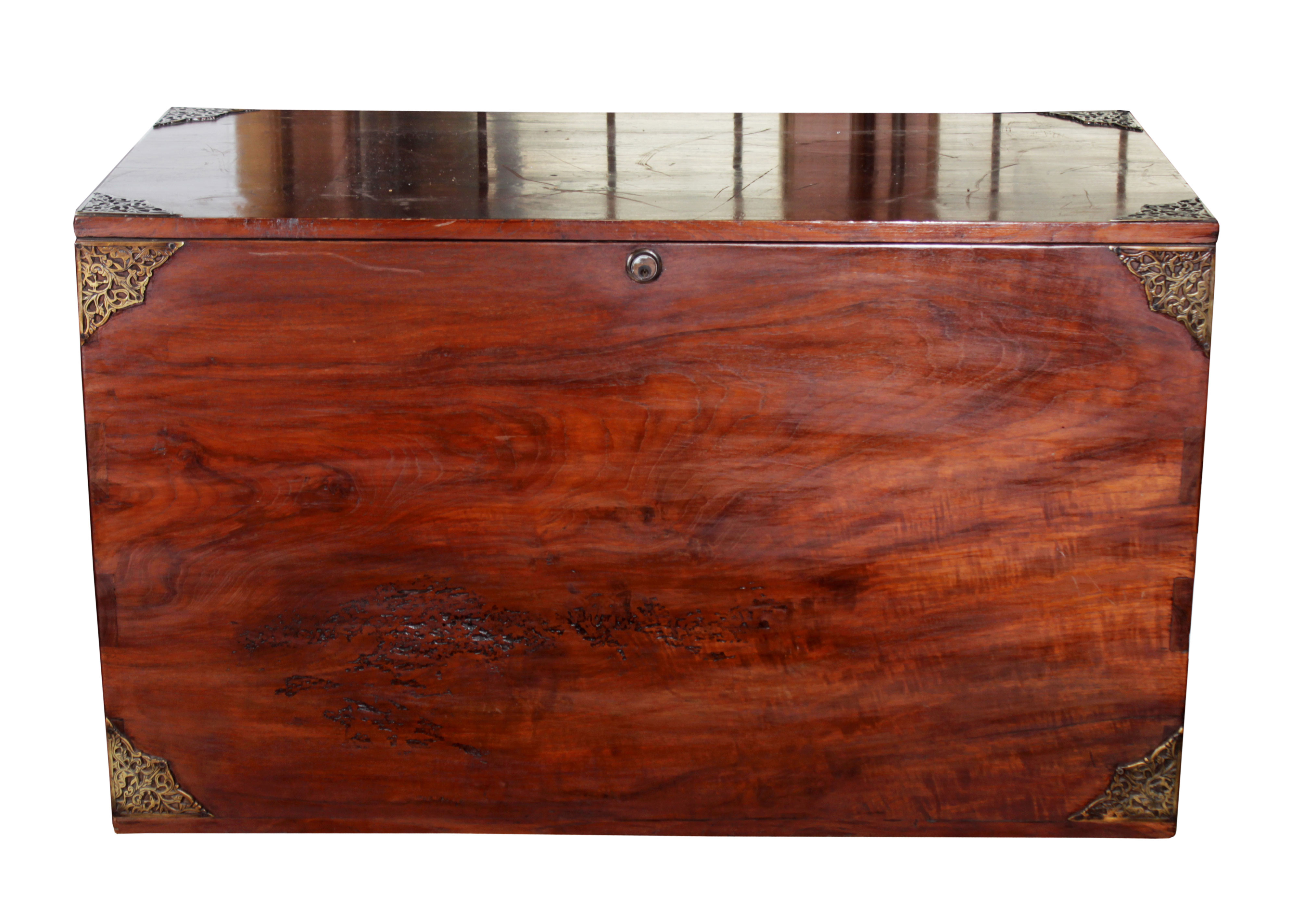 A wooden chest with brass ornaments on eachcorner.