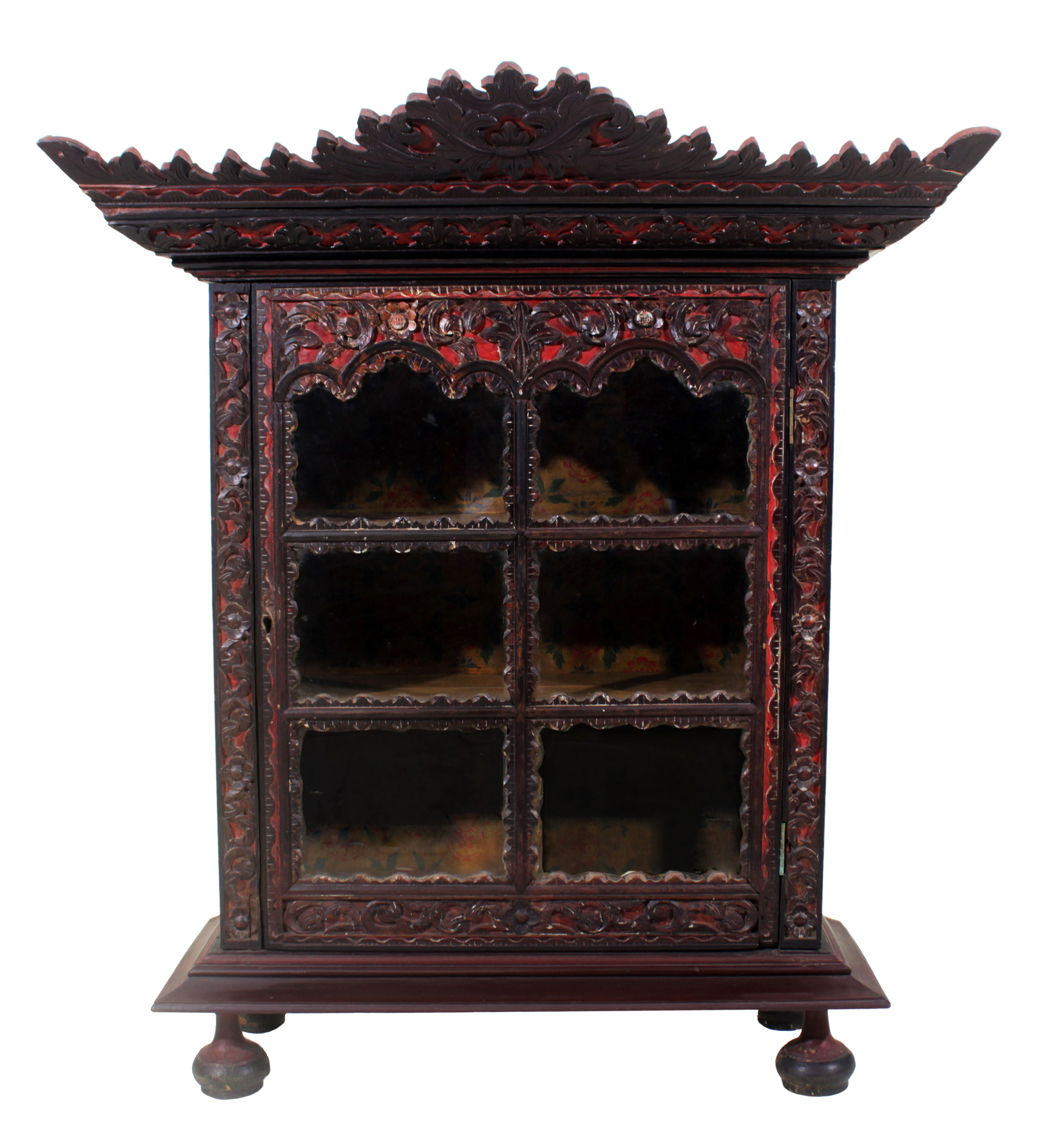 A small brown wooden Palembang cabinet with carved and panelled glass doors.