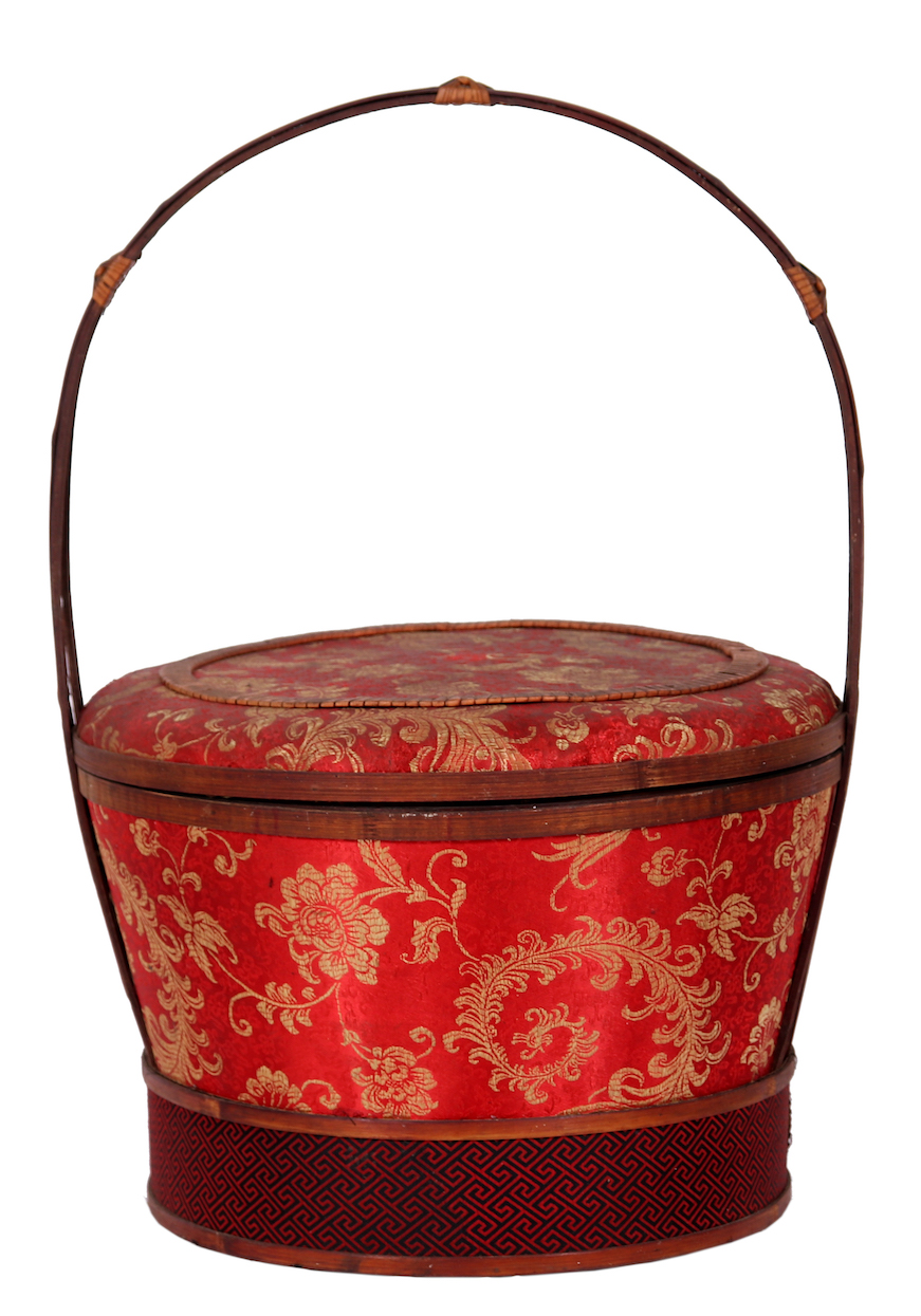 A bamboo basket covered with an elegant Chinese fabric.