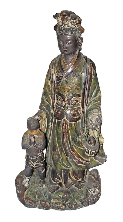 A Shiwan figure of standing Guan Yin with a boy