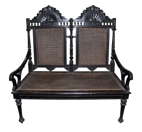 A carved teak settee armchair