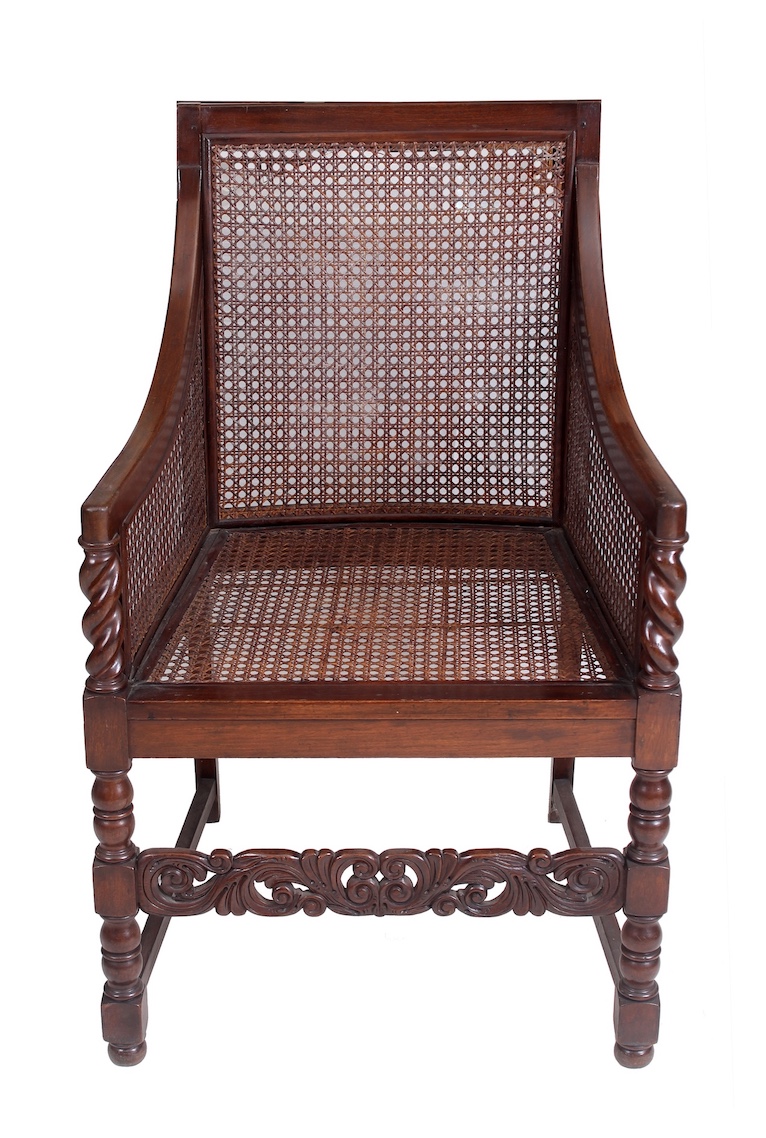 A pair of early 20th century carved teak arm chairs with rattan seat and back
