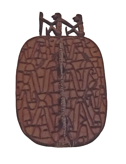 A carved wood tribal style wall plaque