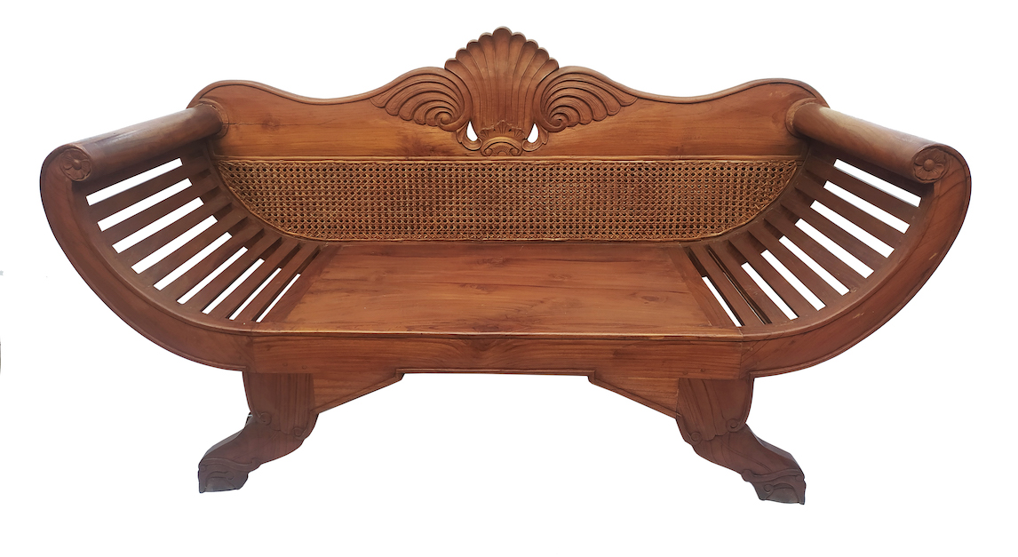 An early 20th century carved teak sofa with rattan back 