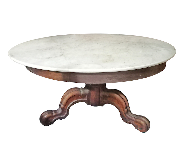 A carved teak round table with marble top