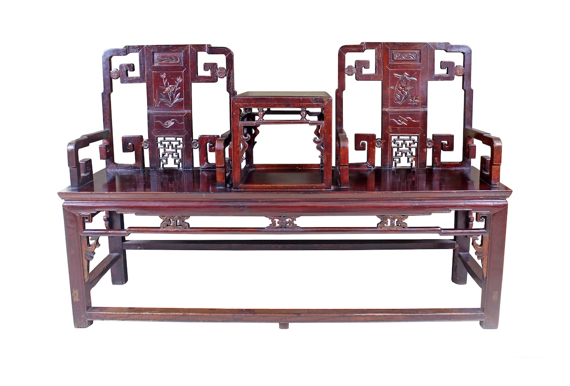 A Chinese carved wood settee with a small table