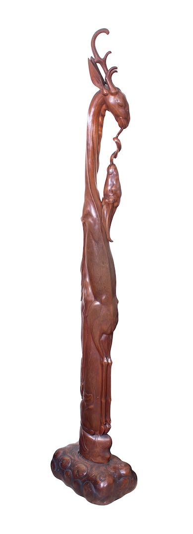 A modern carved teak model of deers