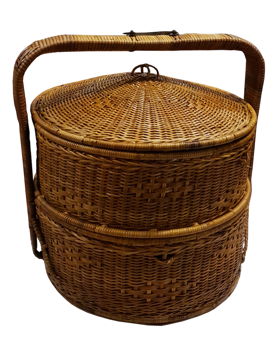 A vintage two tiered cane basket and cover