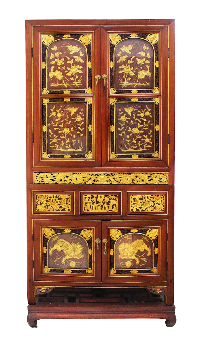 A late 19th - early 20th century Peranakan Chinese carved brown and gold tiered cupboard with stand