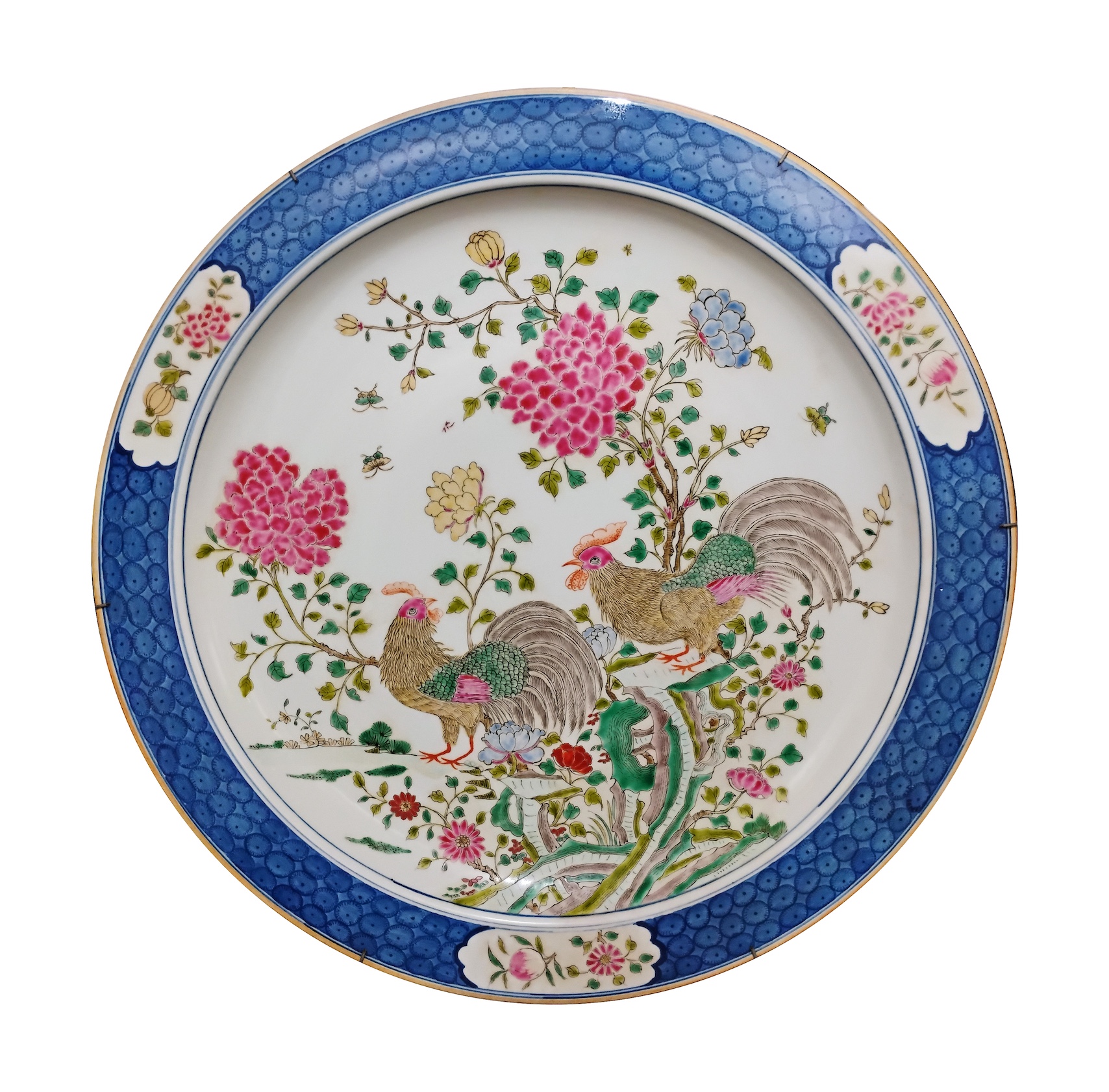 A large polychrome dish painted with roosters in famille rose with blue rim